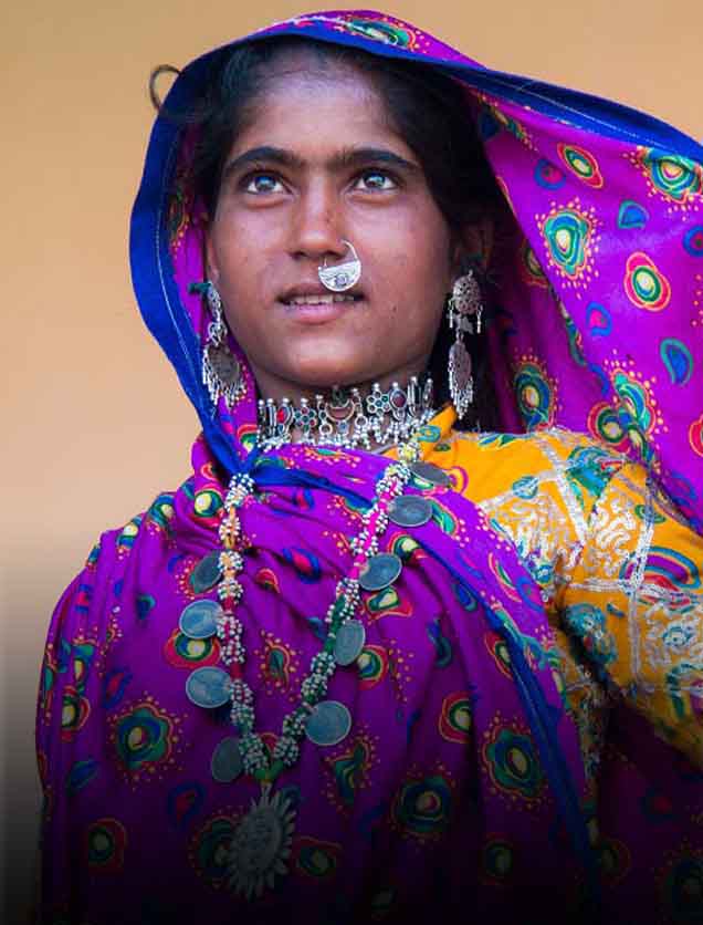 Tribal Tour To India On MotorcycleI A tribal Gujarati  woman exhibiting a traditional outfit of bright ghagra- choli & a veil