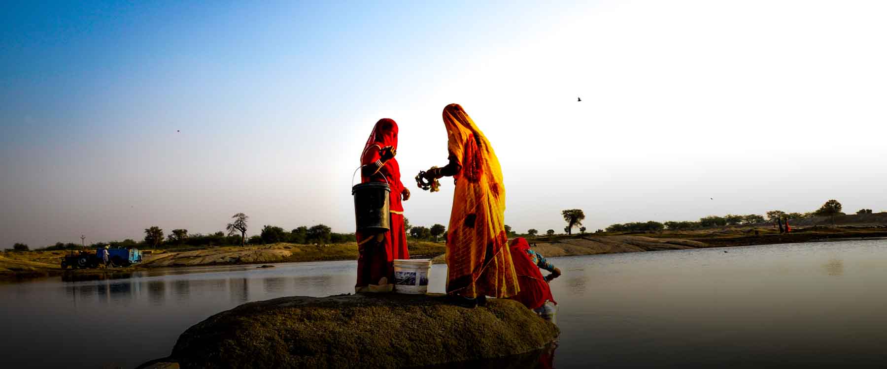 Rajasthani women in a village of Rajasthan fetching water from a natural lake I women of Rajasthan Dressed in bright clothes
