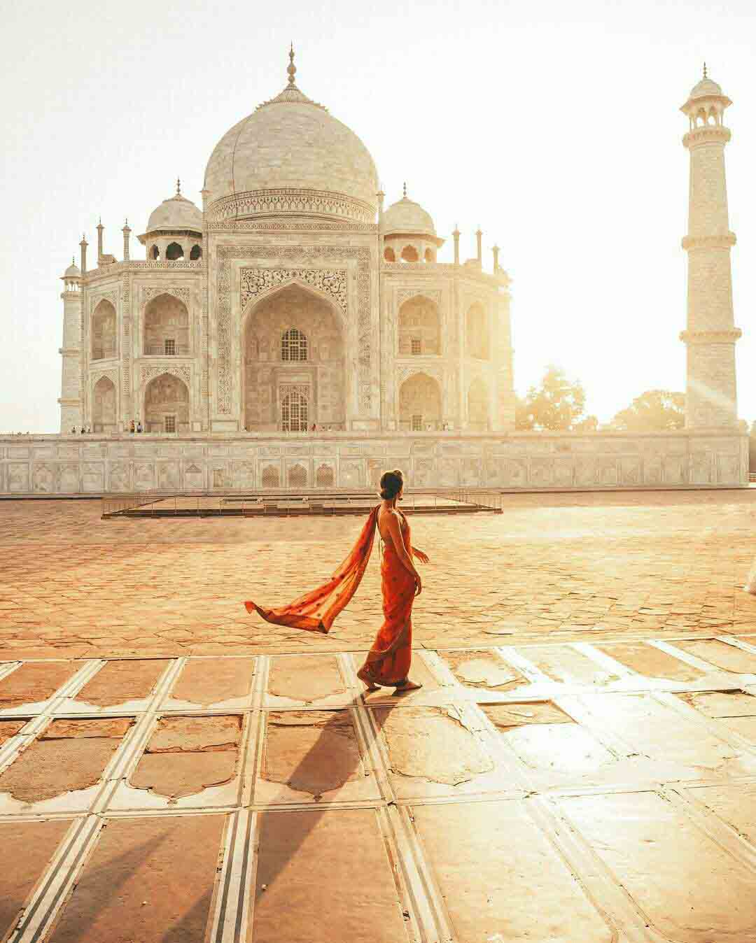 A Tourist clad in a bright Indian Saree in front of enchanting the Taj Mahal I Explore UNESCO sites of India on a Motorcycle