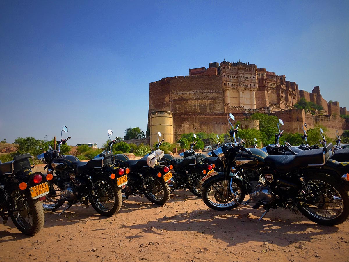 A fleet of Royal Enfield Bikes parked against the majestic Mehrangarh Fort of Jodhpur I Diwali Festival Tour to India On Bike