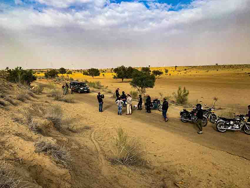 A group Tour to Rajasthan on Royal Enfiled I A group of bikers taking rest on the dunes of Rajasthan, India I Travel India
