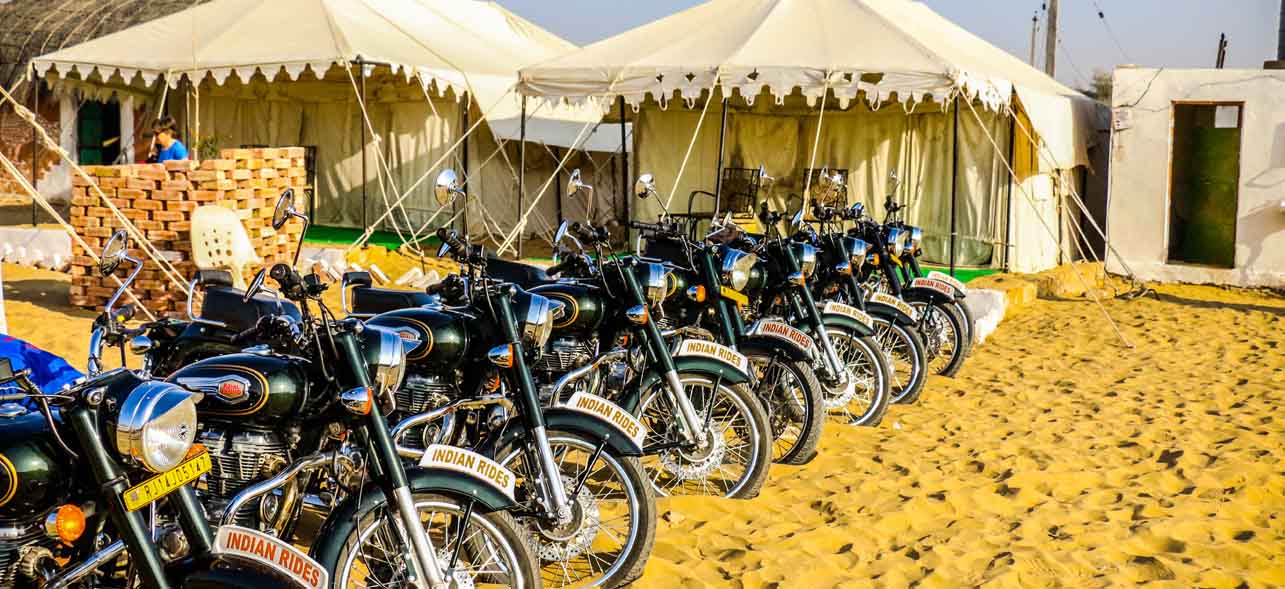 Campground in Rajasthan I Motorcycle fleet in front of luxurious night tents in Rajasthan I Motorcycle camping Tour in India