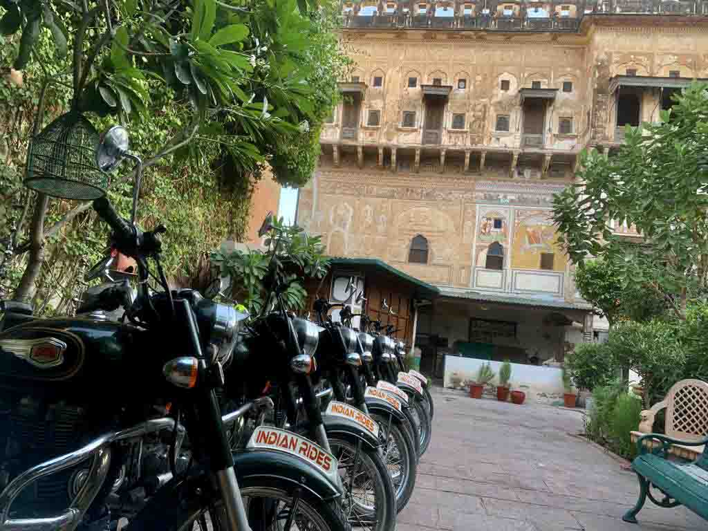 The Mandawa Haveli of Rajasthan I Fresco Art seen on the walls of Haveli I A fleet of Indian Rides Parked against the haveli
